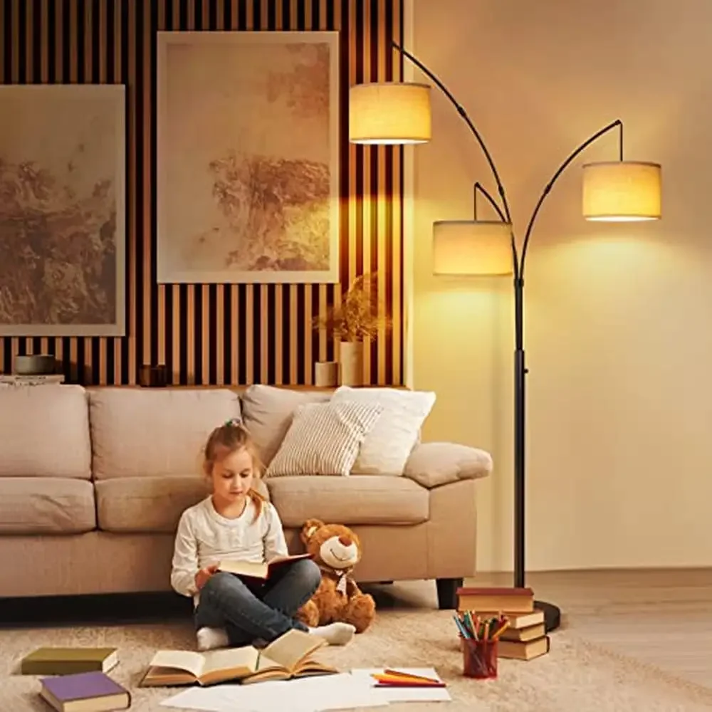 Multi-arm black arc floor lamp strategically positioned to illuminate living room seating area