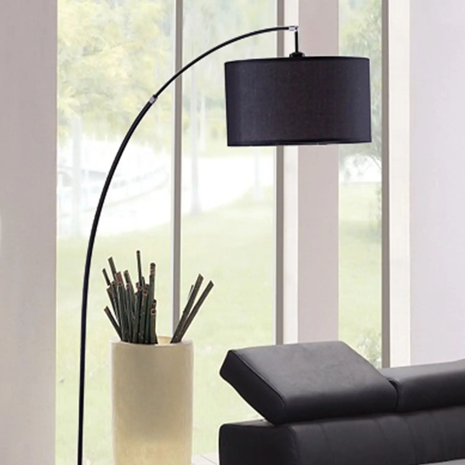 Large arc lamp strategically positioned to create a defined reading area in an open space