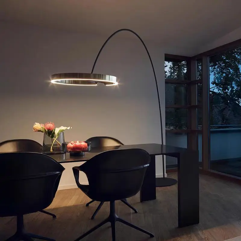 Modern gold arc floor lamp elegantly positioned over a dining area